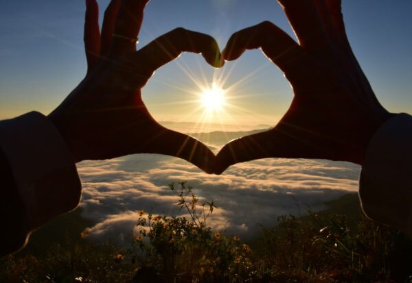 Kobieta pokazuje serduszko, w dowód, że kocha góry
